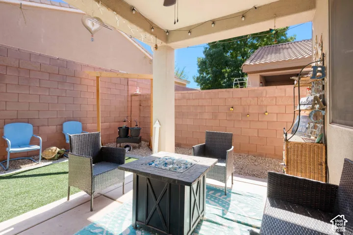 Covered patio with string lighting, paver flooring, and a built-in fire pit