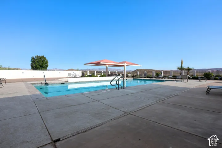 Swimming pool with concrete decking and a red shade structure