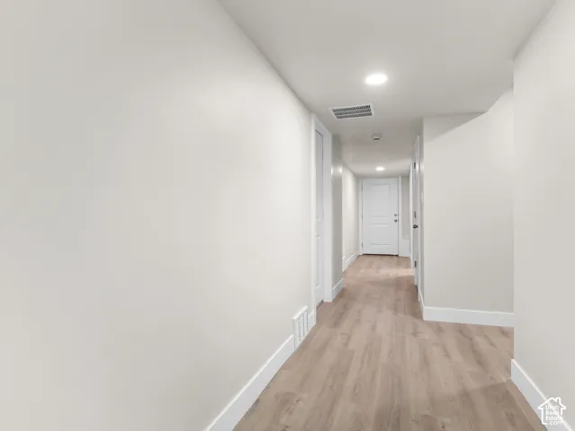 Wood-finish flooring, recessed lighting, white walls, and white trim