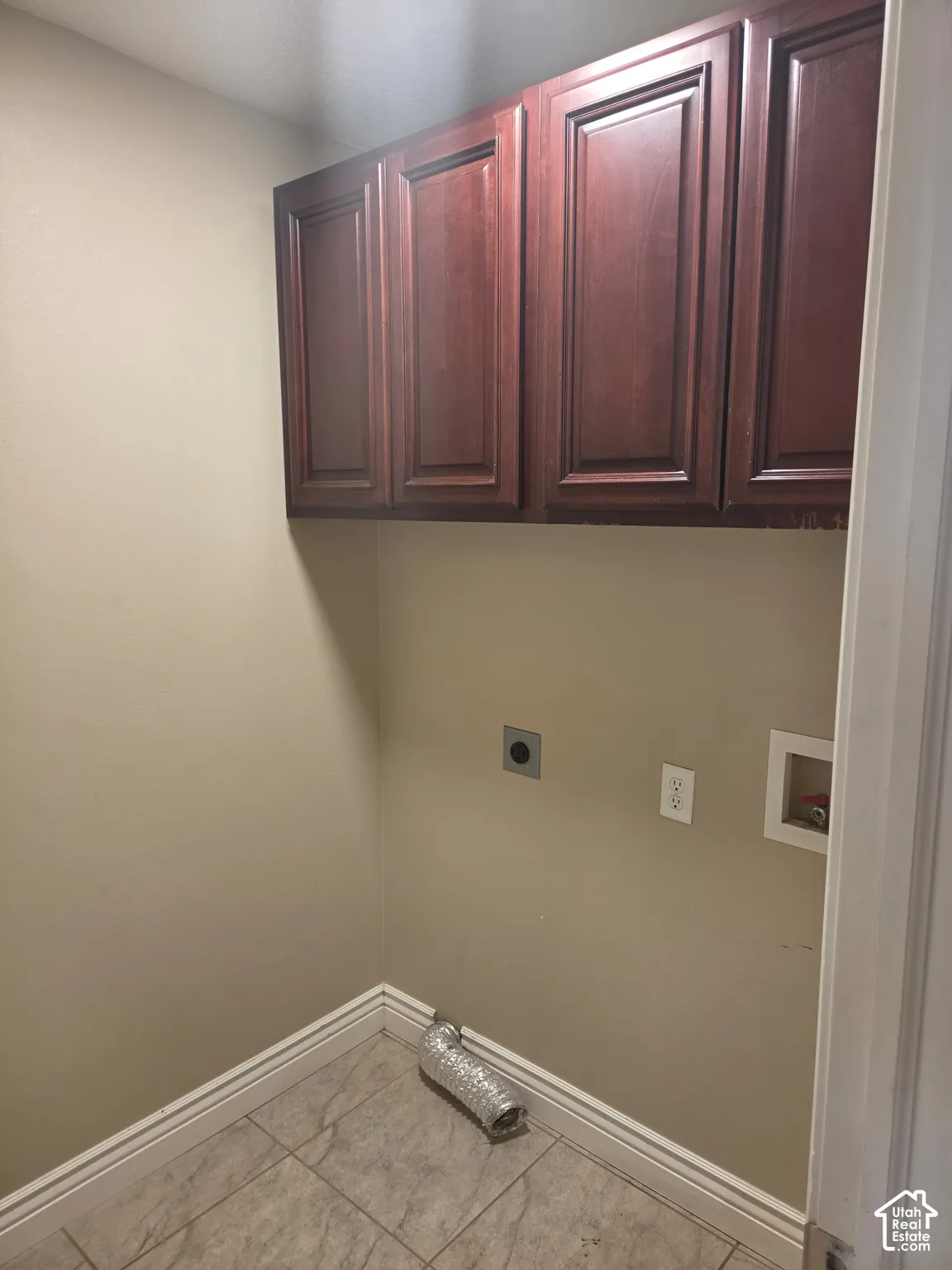 Overhead cabinetry with wood-finish doors, tiled flooring, and neutral wall paint