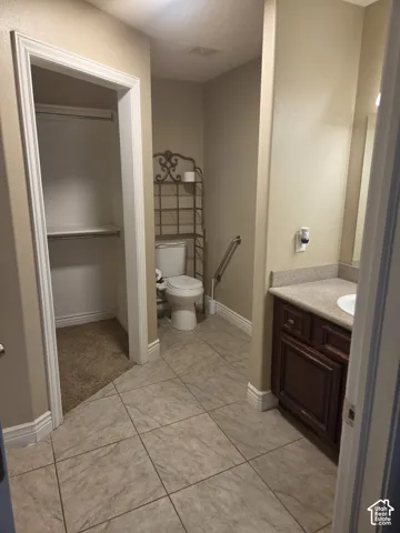 Tile flooring complemented by a rich wood-finish vanity and integrated sink