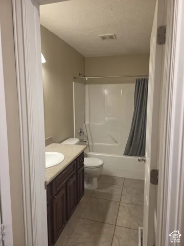 Bathroom featuring a single vanity with dark wood-finish cabinetry, a white basin, and a light-colored countertop