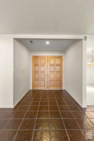 Double wooden entry doors, tile flooring, recessed lighting, and neutral wall finishes