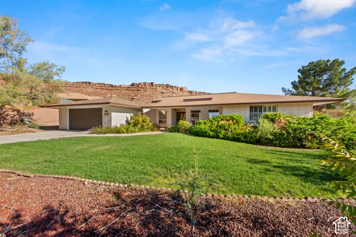 Single-story residence featuring a brick exterior and an attached two-car garage