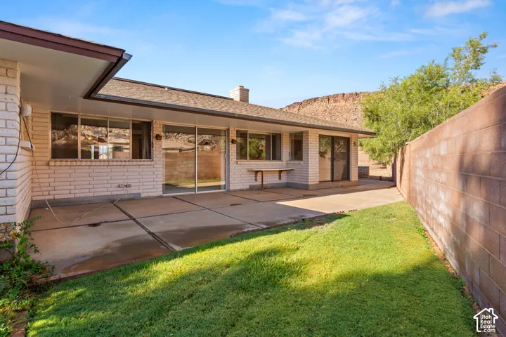 Expansive patio area with concrete surfacing, adjacent to a grassy lawn