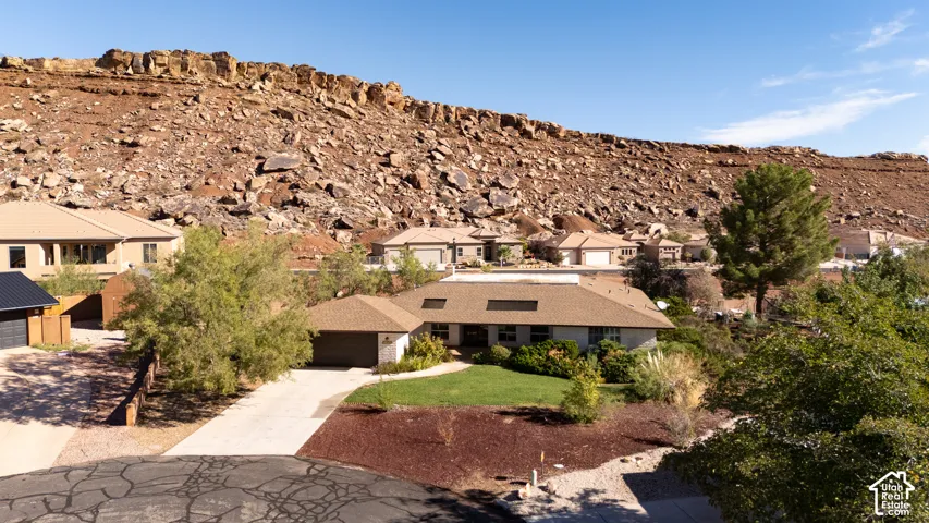 Single-story residence with an attached garage, featuring a paved driveway and a manicured front lawn