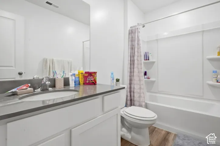 White vanity with a single basin sink, light gray countertop, and chrome faucet