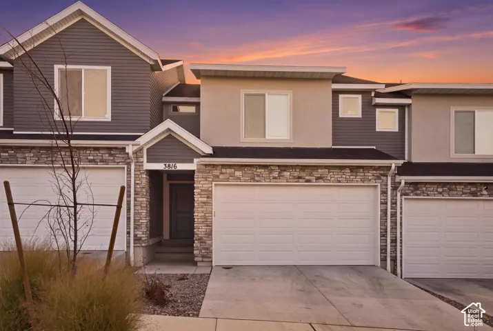 Multi-level townhome featuring stone veneer and horizontal siding