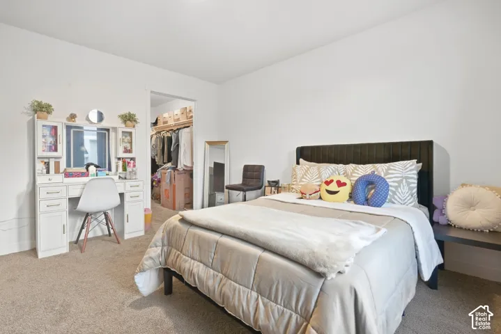 Neutral wall color, carpeted flooring, and a built-in closet with shelving