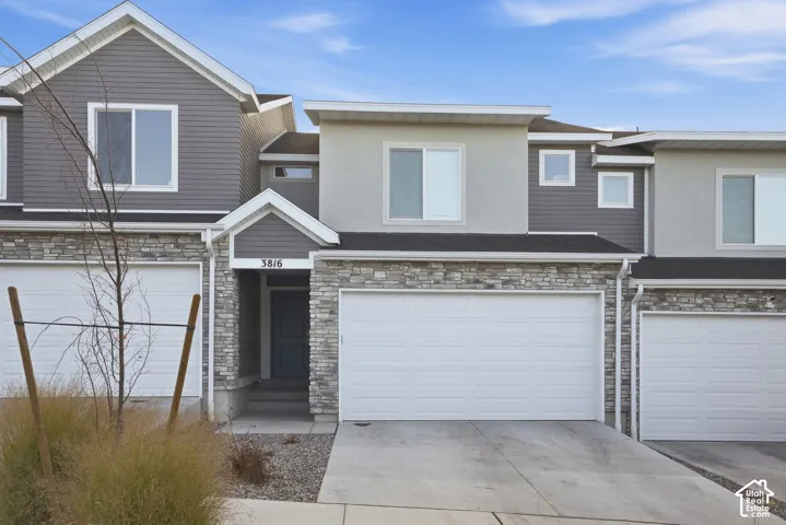 Contemporary exterior with stone veneer accents, horizontal siding, and stucco finishes