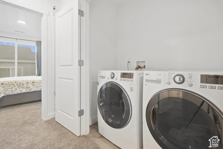 Laundry area with light-toned wall paint and wood-finish flooring