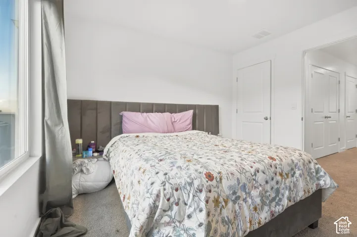 Wall-to-wall carpeting with light-toned walls and trim, featuring a large window