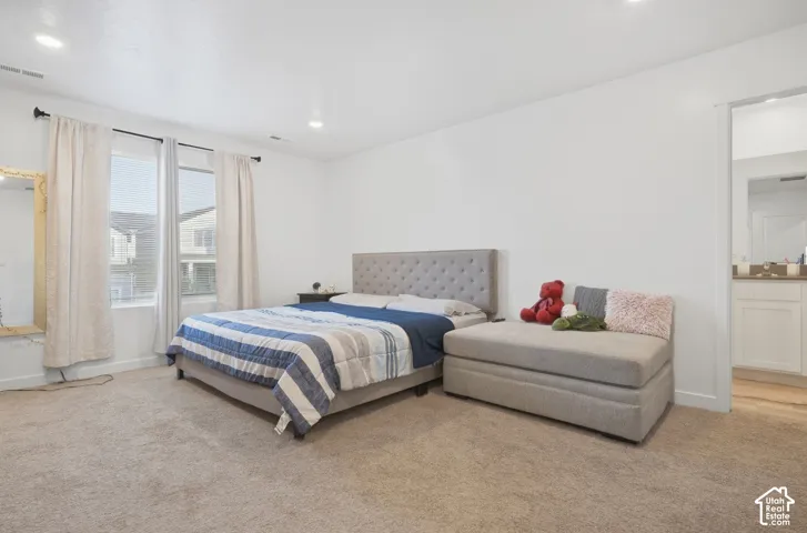 Recessed lighting, light-toned carpeting, and a window with blinds and drapes