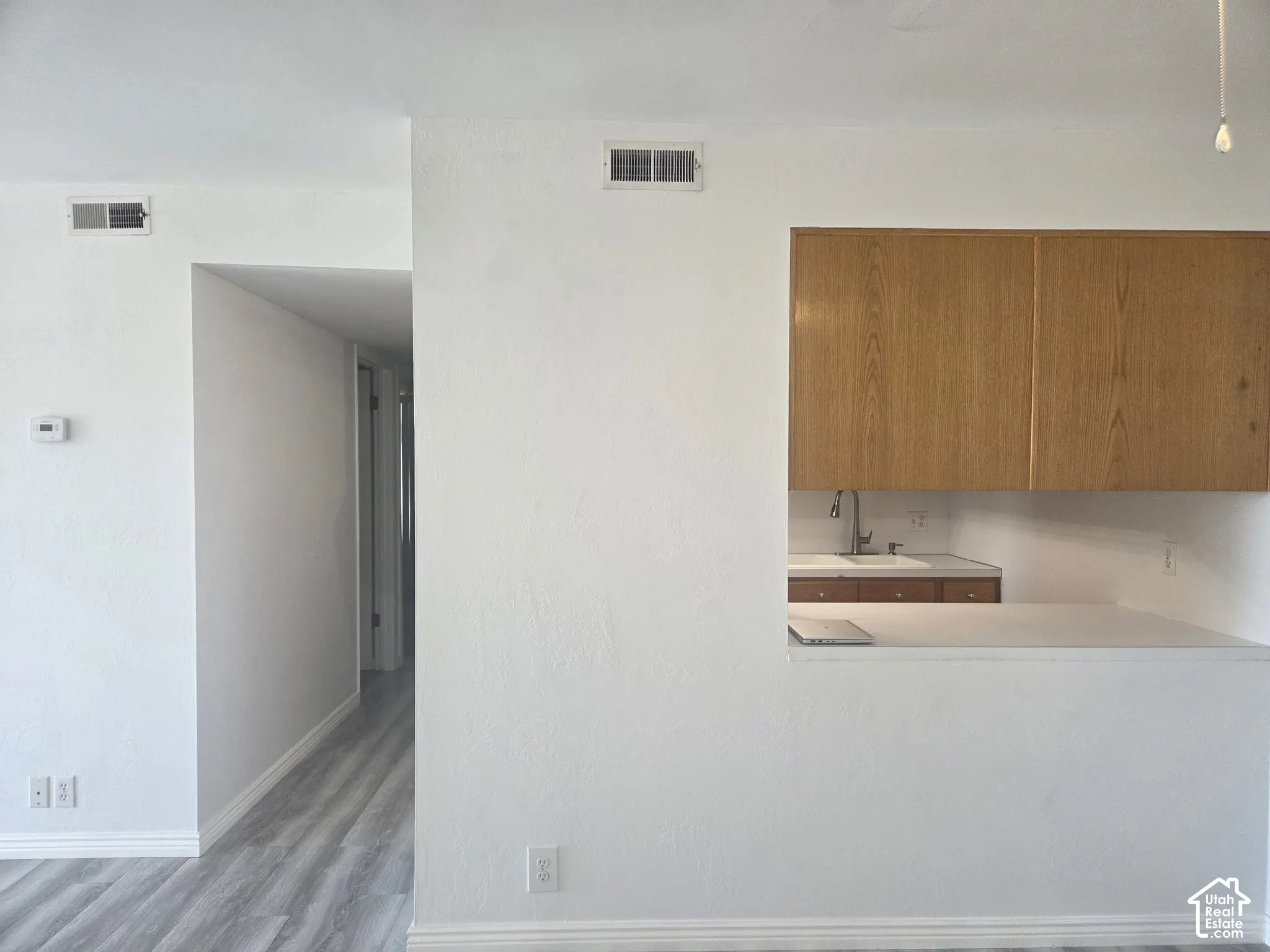 LVP flooring, white walls, and a pass-through window with a countertop