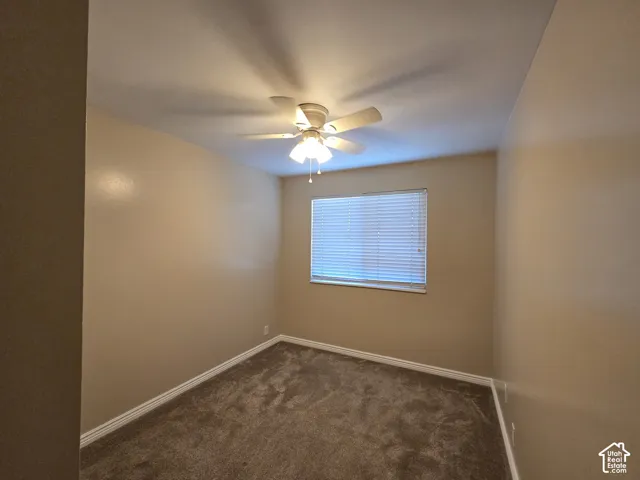 Recessed window with blinds, ceiling-mounted fan, and carpeted flooring