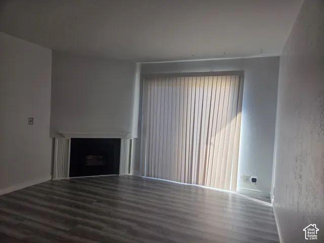 LVP flooring and a fireplace with a white mantel and surround