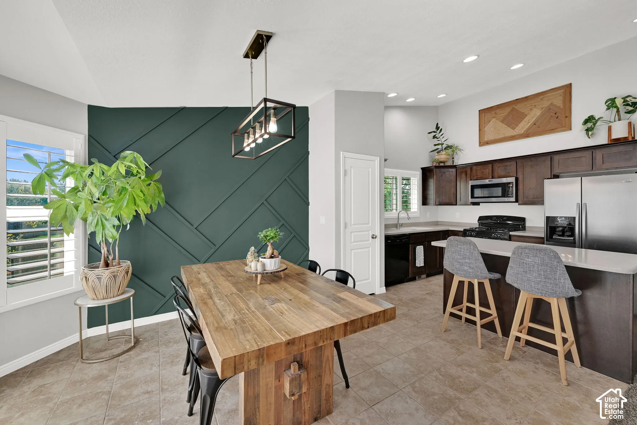 Kitchen and dining area featuring a geometric accent wall, recessed lighting, and a kitchen island with seating