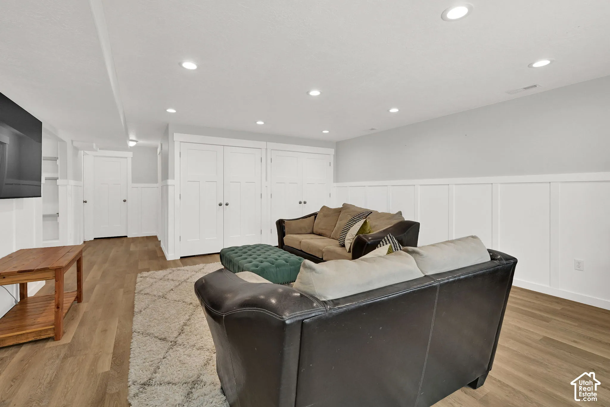 Recessed lighting illuminates wood-finish flooring and wainscoting