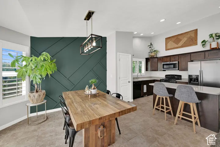 Kitchen and dining area featuring a geometric accent wall, recessed lighting, and a kitchen island with seating
