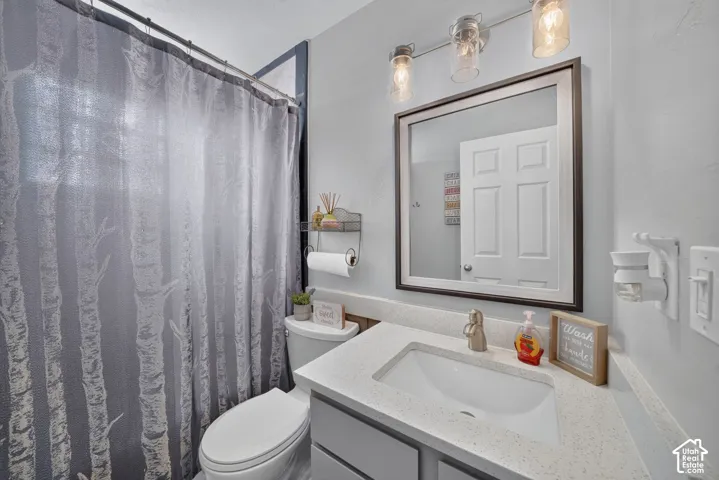 Vanity with integrated rectangular sink, stone-finish countertop, brushed nickel faucet, and a framed wall mirror