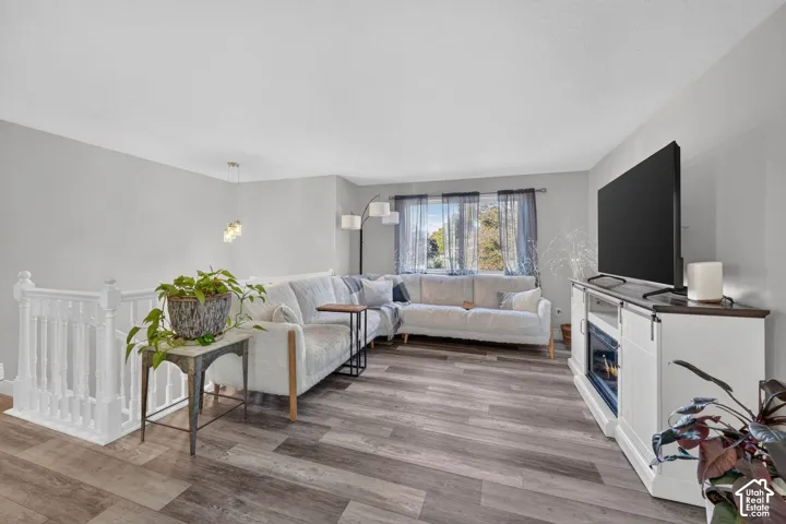 Wood-finish flooring throughout, white painted railings, recessed window, and pendant lighting