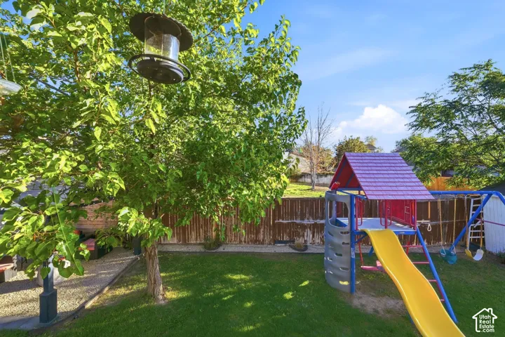 Expansive backyard featuring a green lawn, mature trees, and privacy fencing