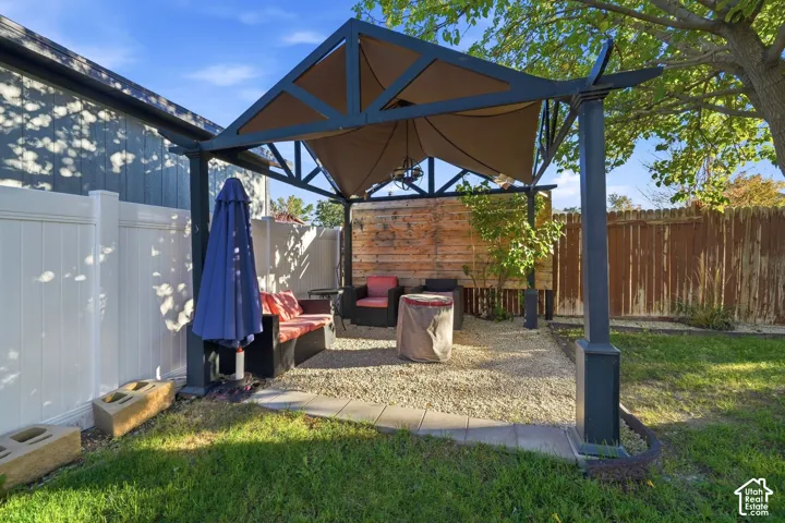 Outdoor seating area with a covered pergola, gravel ground cover.