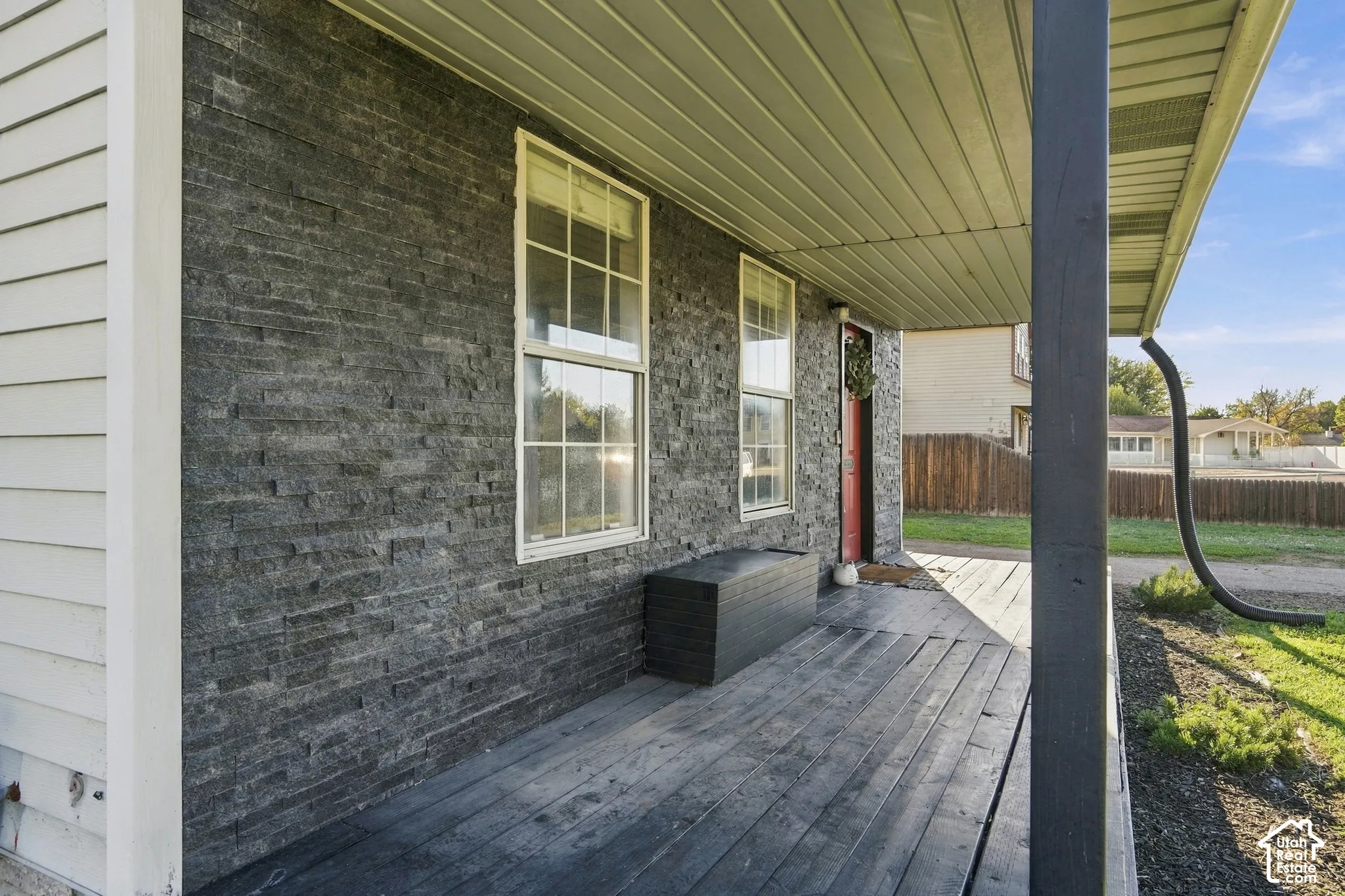 Front porch featuring dark wood-finish flooring and a stone veneer exterior wall