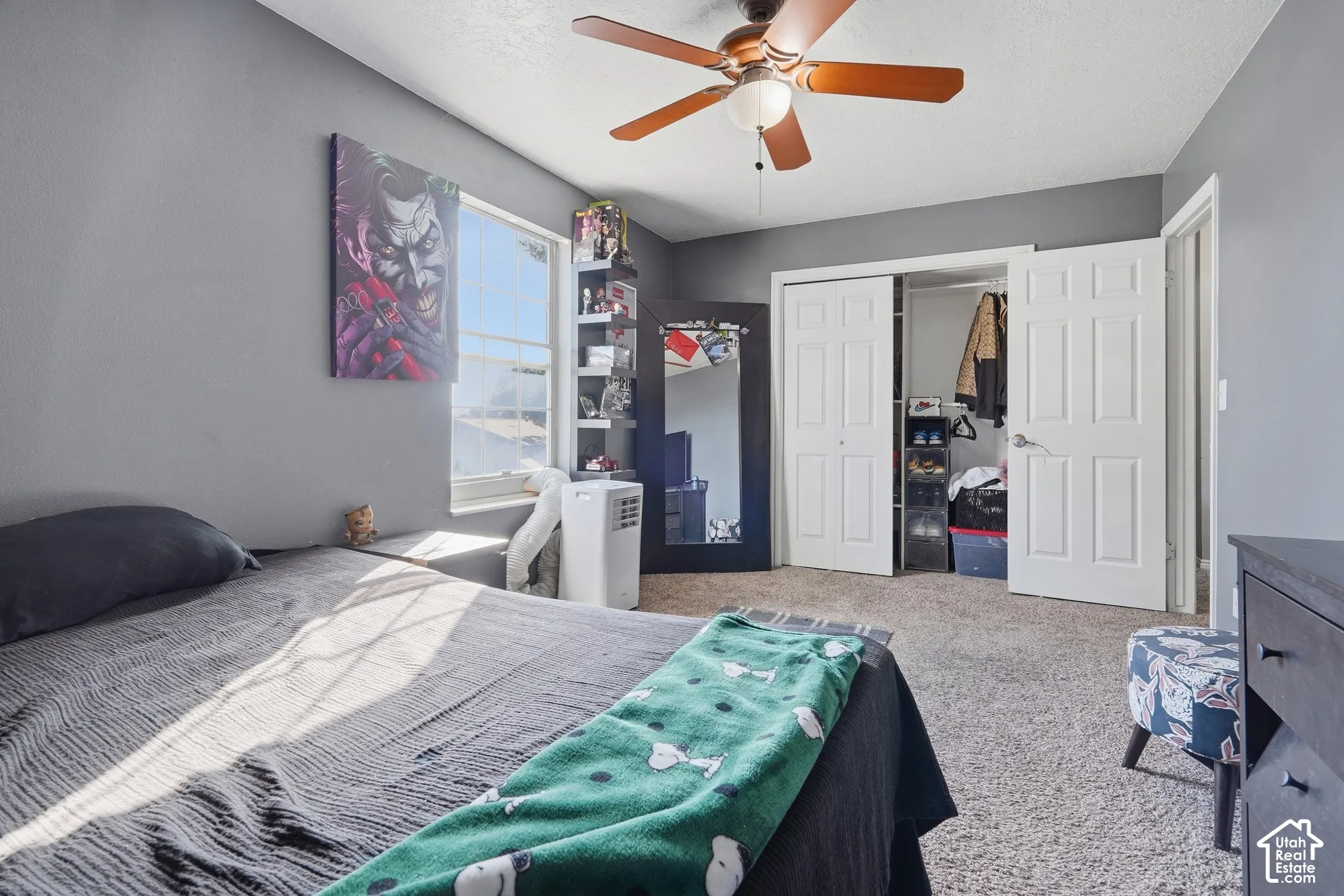 Carpeted flooring, ceiling fan, white trim, sliding closet doors, and a window