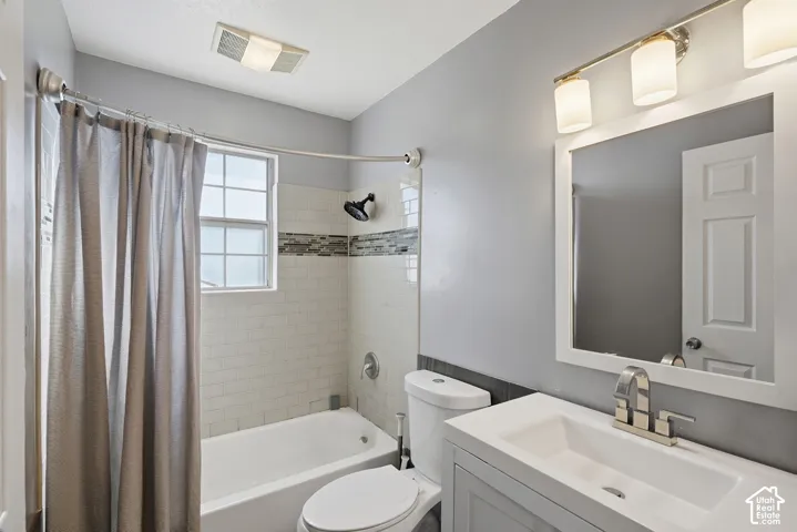 White subway tile shower surround with mosaic accent band, contemporary vanity with integrated sink, brushed nickel faucet, and a wall-mounted mirror