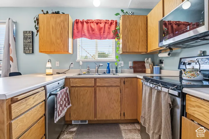 Kitchen featuring wood-finish cabinetry, solid surface countertops, a stainless steel dishwasher, and a built-in microwave oven