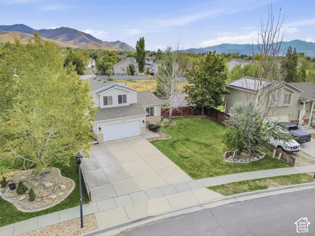 Two-story residence featuring a two-car garage, mature landscaping, and a substantial driveway