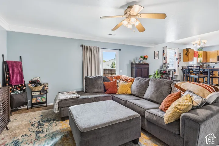 Recessed lighting, crown molding, ceiling fan with integrated lighting, wood-finish flooring, and a kitchen with wooden cabinetry