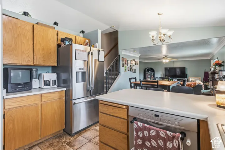 Kitchen featuring wood cabinetry, light-toned countertops, and a stainless steel refrigerator