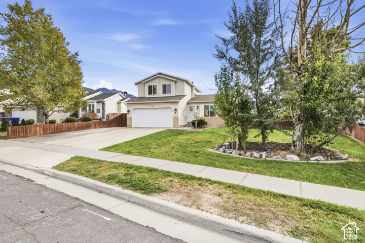 Two-story residence with a two-car garage, concrete driveway, and front lawn