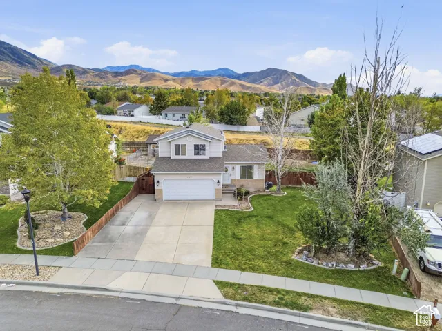 Two-story residence with a two-car garage, concrete driveway, and front lawn
