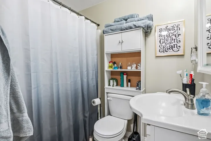 Vanity with integrated sink, brushed nickel faucet, wall-mounted mirror, and white storage cabinet