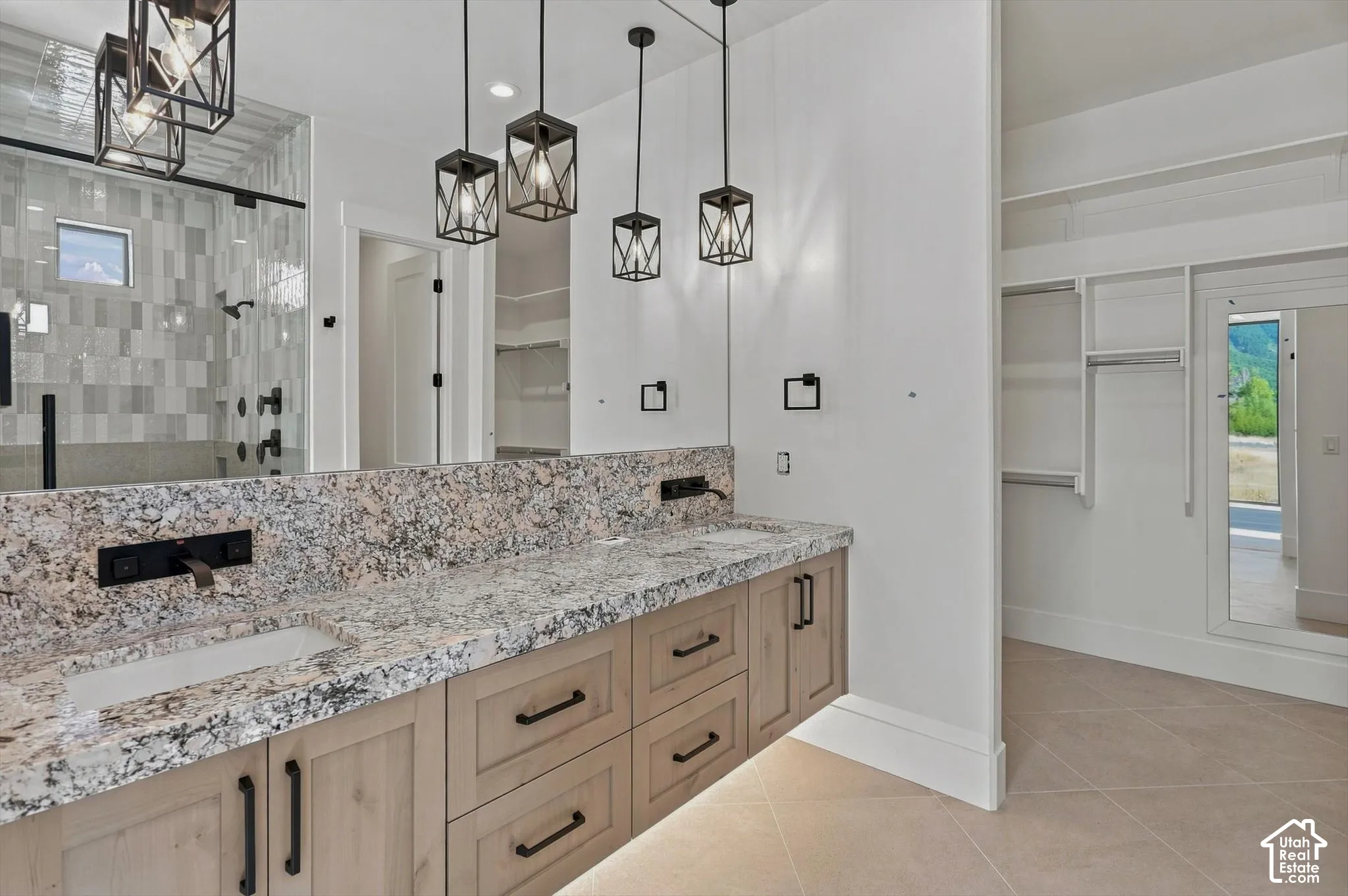 Dual vanity with stone countertop, integrated sinks, and wall-mounted faucets
