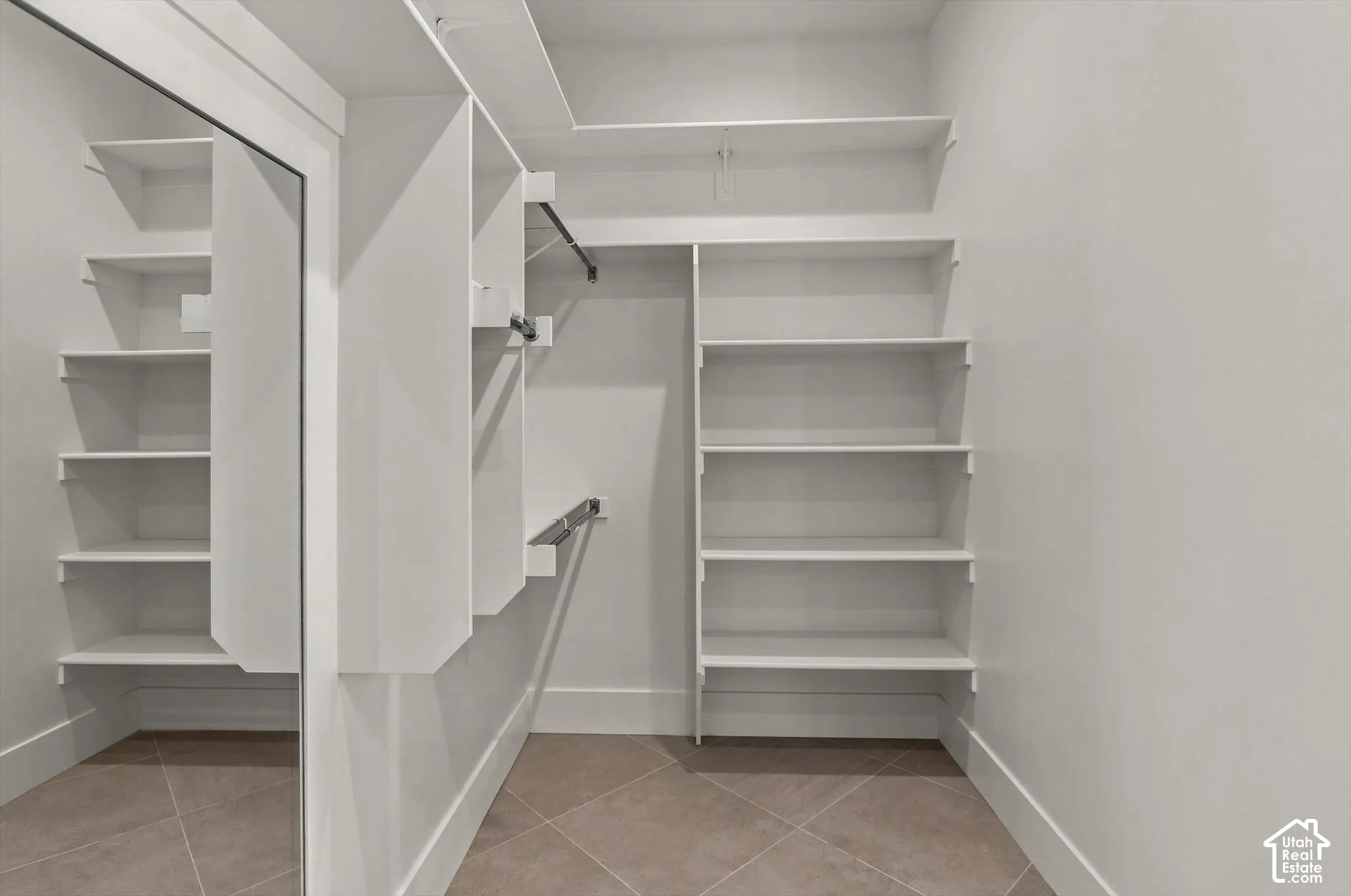 Built-in shelving, hanging rods, and tile flooring