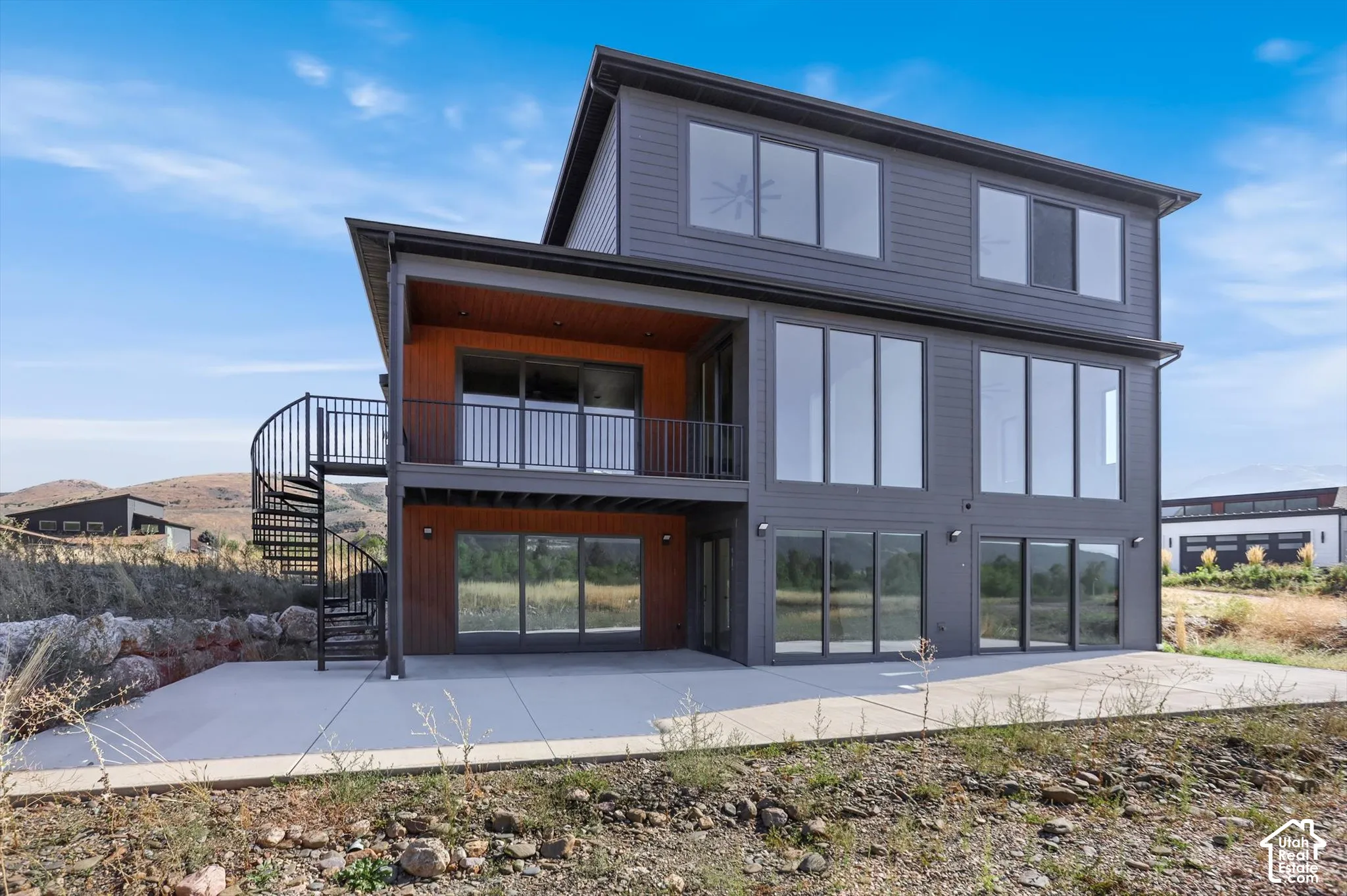 Contemporary exterior featuring gray siding and extensive window placements