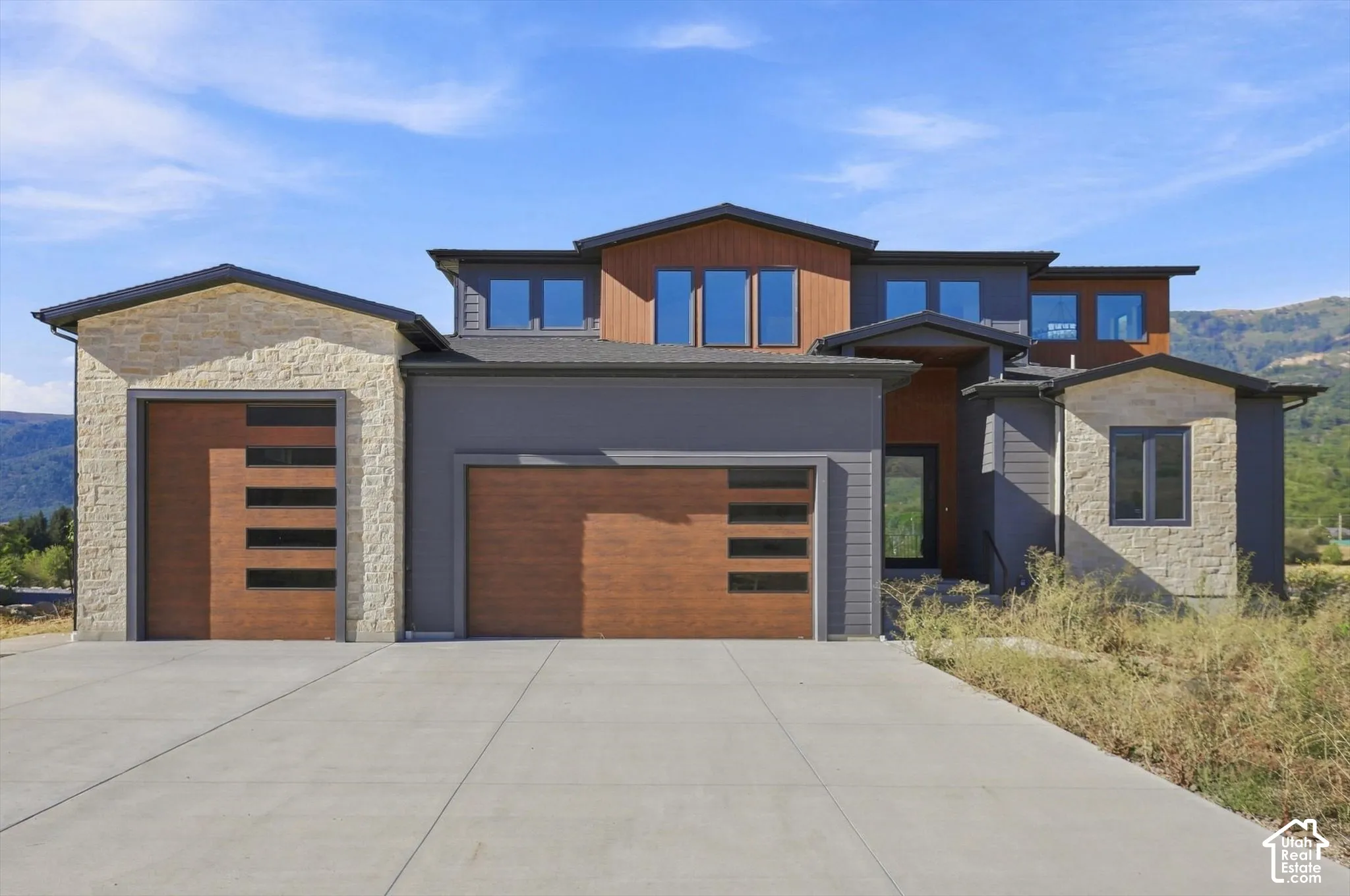 Modern architectural style featuring stone and wood-finish siding