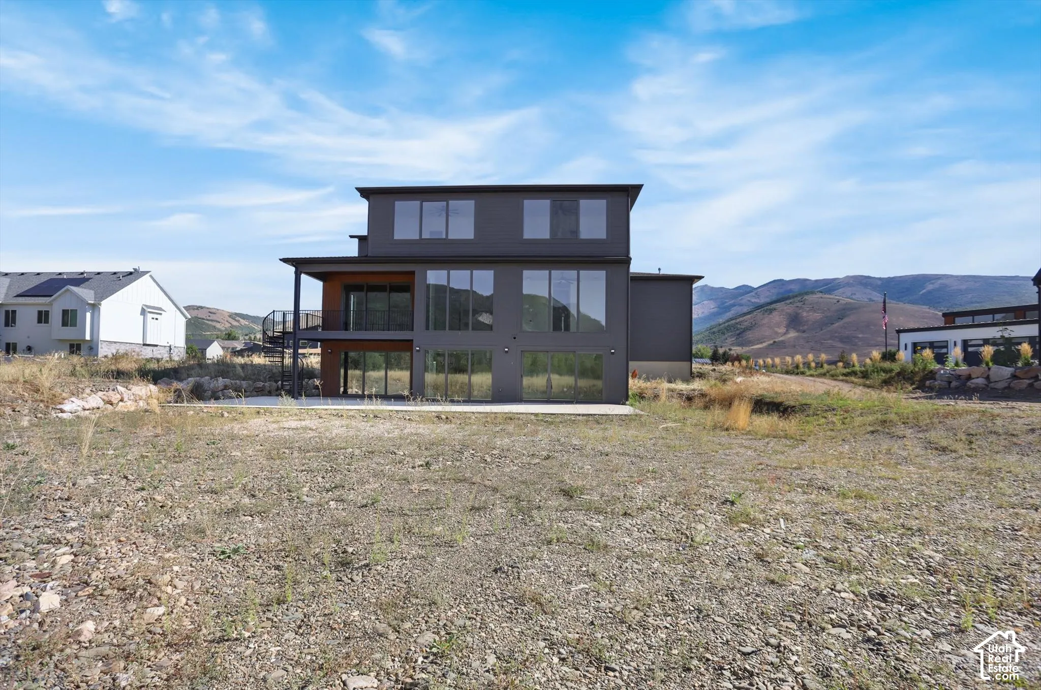 Modern multi-story property with a dark-toned exterior and expansive window placement