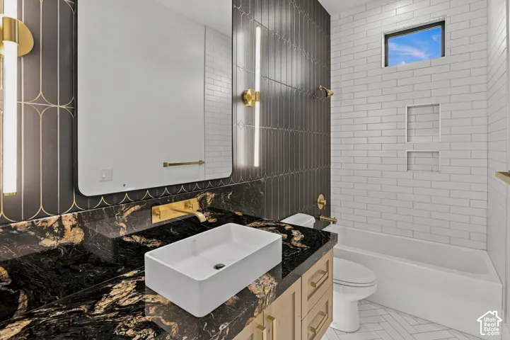 Black granite vanity with a rectangular vessel sink and wall-mounted gold-finish faucet