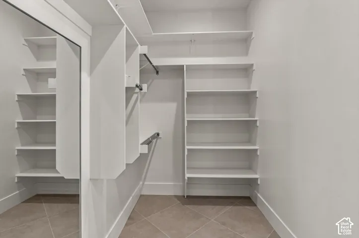 Built-in shelving, hanging rods, and tile flooring