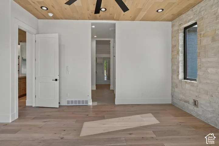 Hardwood flooring, stone accent wall, recessed lighting, and wood-finish ceiling