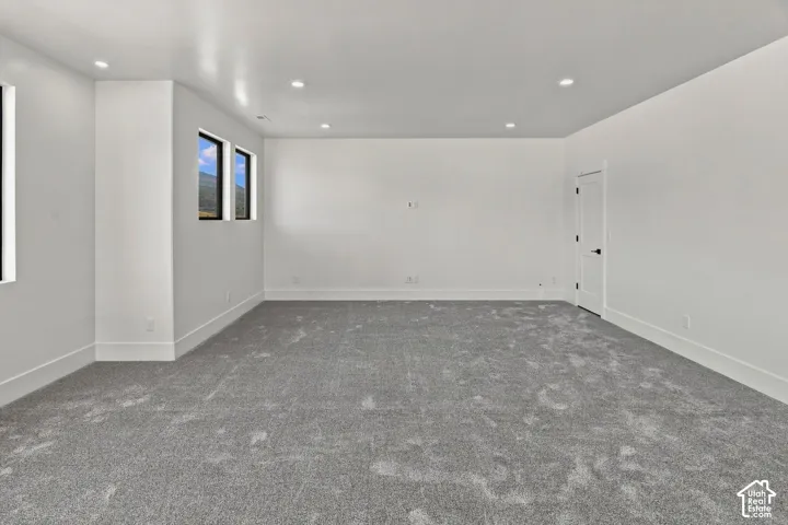 Spacious interior featuring neutral carpeting, recessed lighting, and multiple windows with mountain scenery