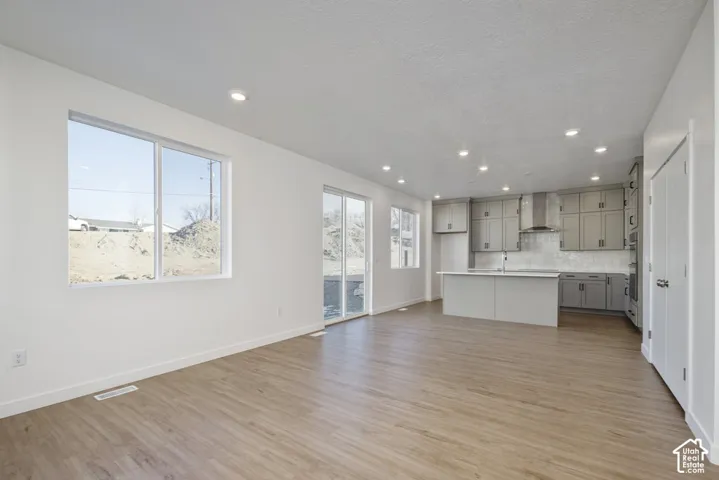 Open-concept living space featuring wood-finish flooring, recessed lighting, and white walls