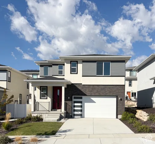 Contemporary exterior featuring a white garage door, black brick accents, and a red entry door