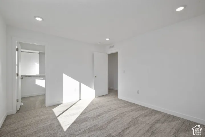 Recessed lighting, light gray carpeting, and white walls