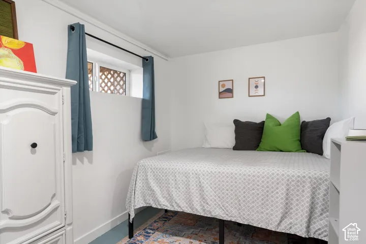 Clean white walls with a prominent window well, featuring a window and white lattice